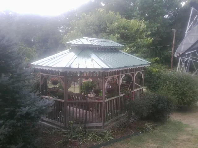 Green metal roof on a backyard gazebo surrounded by garden beds in Hume